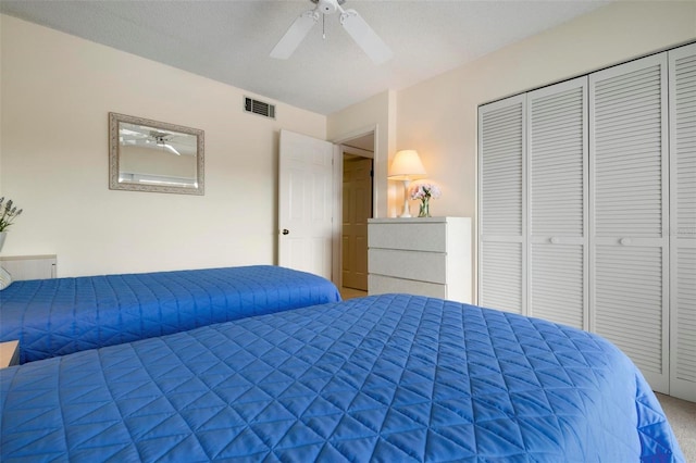 bedroom with carpet, a textured ceiling, a closet, and ceiling fan