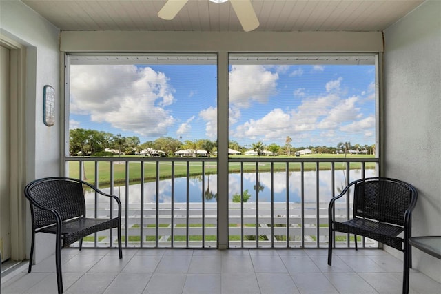 sunroom / solarium with a water view, a wealth of natural light, and ceiling fan