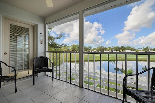 balcony featuring a water view and ceiling fan