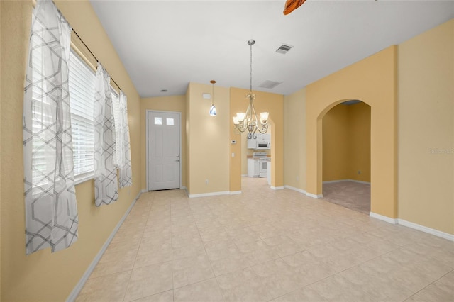 interior space featuring vaulted ceiling, light tile patterned floors, and a chandelier