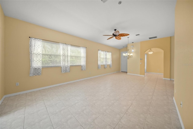 unfurnished room featuring lofted ceiling, light tile patterned floors, and ceiling fan with notable chandelier