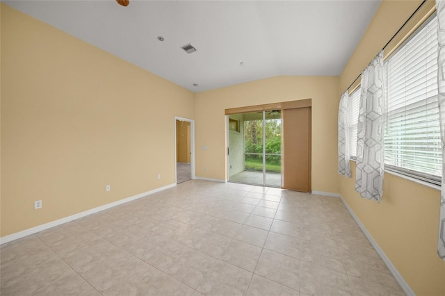 tiled spare room with lofted ceiling