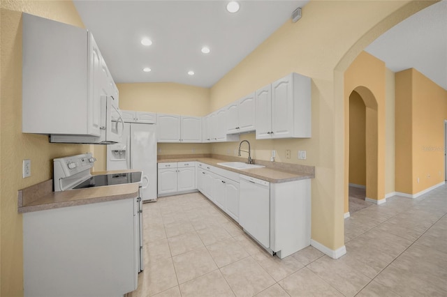 kitchen with vaulted ceiling, white cabinetry, sink, and white appliances