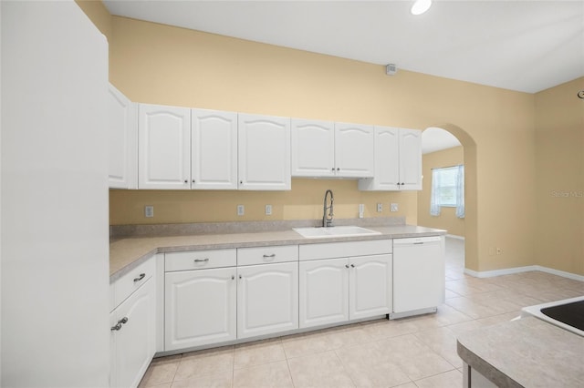 kitchen with dishwasher, light tile patterned floors, white cabinets, and sink