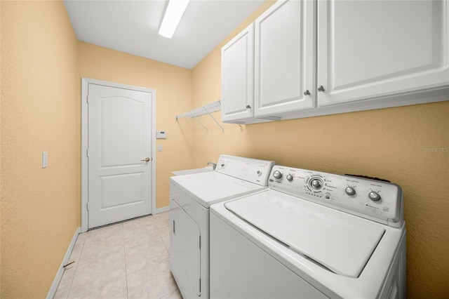 clothes washing area with cabinets, light tile patterned floors, sink, and washing machine and dryer