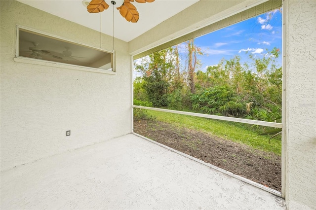 unfurnished sunroom with ceiling fan