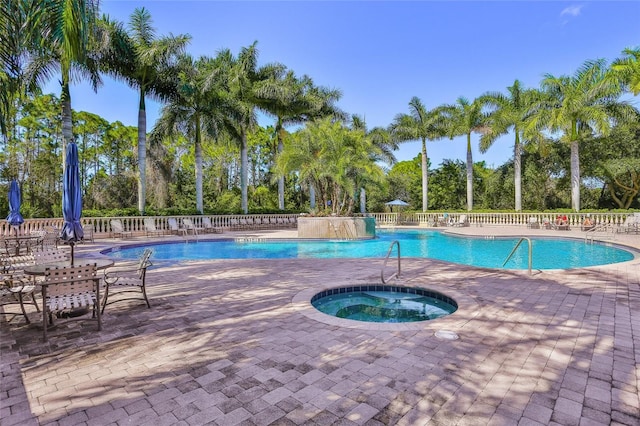 view of swimming pool featuring a patio area and a hot tub