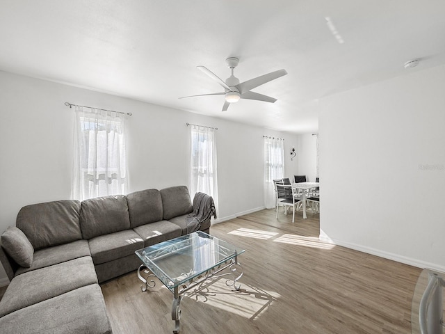 living room featuring hardwood / wood-style flooring, ceiling fan, and plenty of natural light