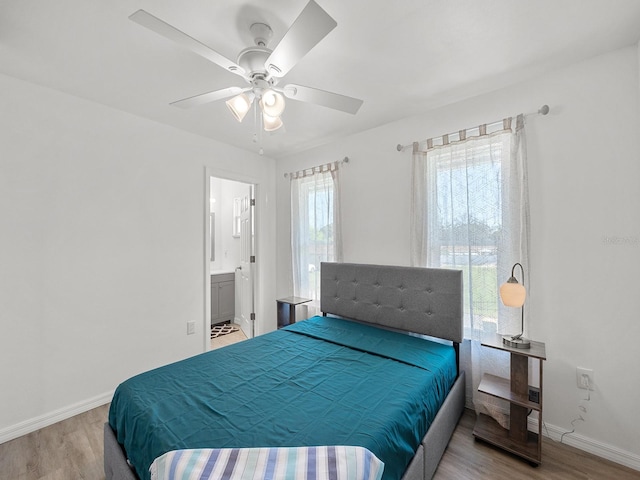 bedroom with light hardwood / wood-style floors, ceiling fan, and ensuite bath