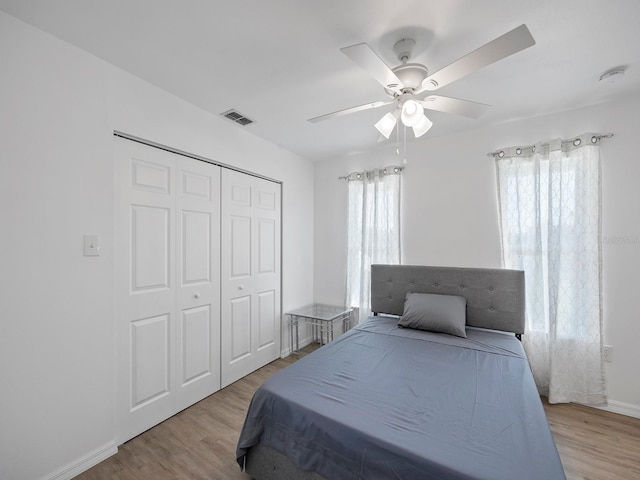 bedroom with ceiling fan, a closet, and light hardwood / wood-style flooring