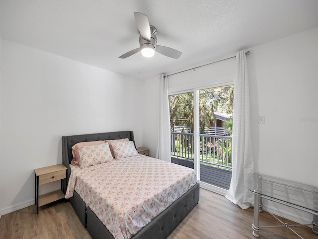 bedroom featuring a textured ceiling, hardwood / wood-style floors, access to outside, and ceiling fan