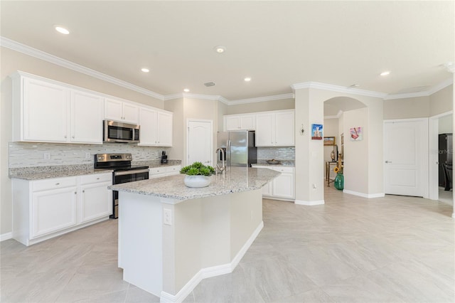 kitchen featuring white cabinetry, a kitchen island with sink, tasteful backsplash, and appliances with stainless steel finishes