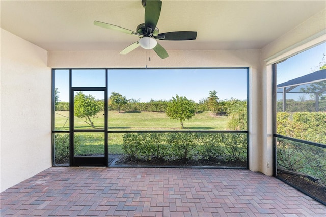 unfurnished sunroom featuring ceiling fan