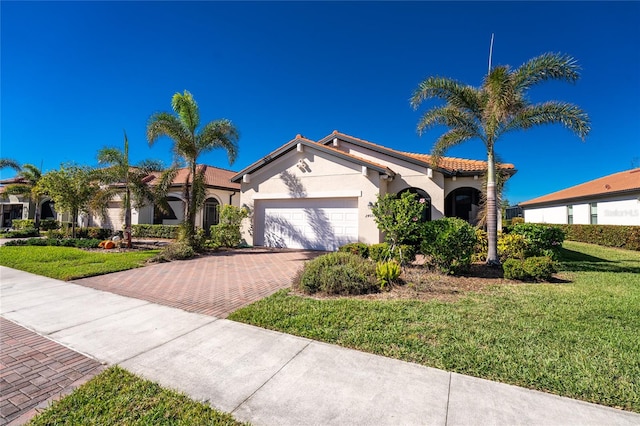 mediterranean / spanish house with a garage and a front lawn