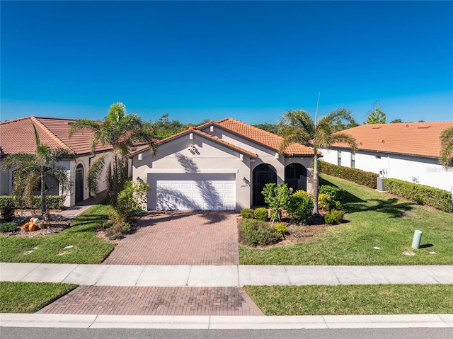 mediterranean / spanish-style home featuring a garage and a front yard