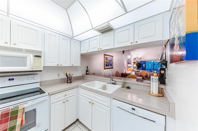 kitchen with white cabinetry, sink, light tile patterned flooring, and white appliances