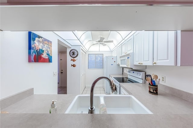 kitchen featuring ceiling fan, sink, white cabinets, and white appliances