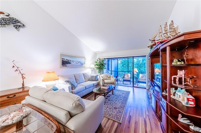 living room featuring high vaulted ceiling and wood-type flooring