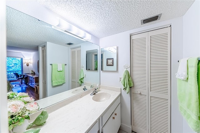 bathroom featuring vanity, wood-type flooring, and a textured ceiling