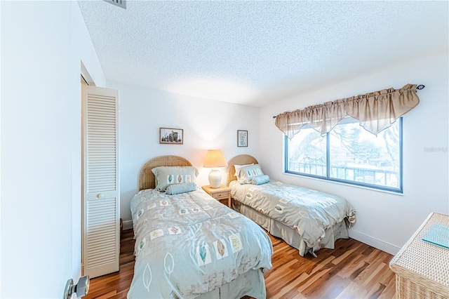 bedroom featuring a textured ceiling, light hardwood / wood-style floors, and a closet