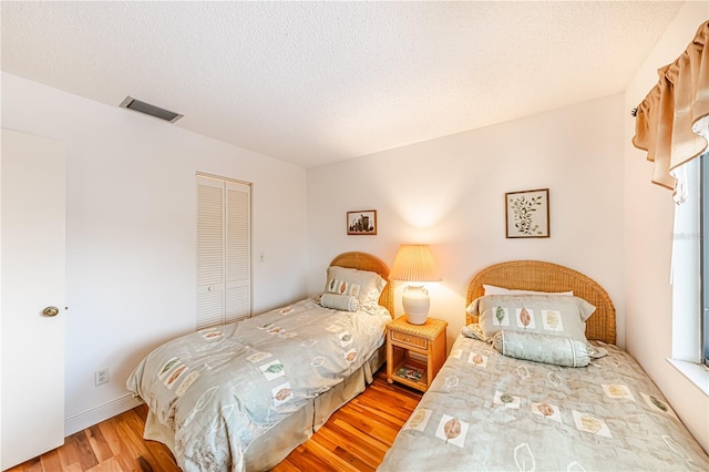 bedroom featuring a closet, hardwood / wood-style floors, and a textured ceiling