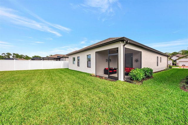 back of property featuring a lawn and a sunroom