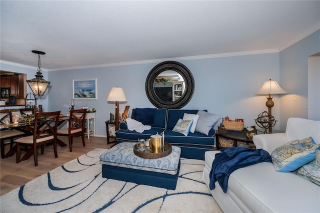 living room with crown molding, wood-type flooring, and a notable chandelier