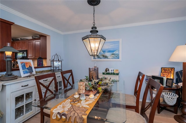 dining area featuring a chandelier, light hardwood / wood-style flooring, and ornamental molding