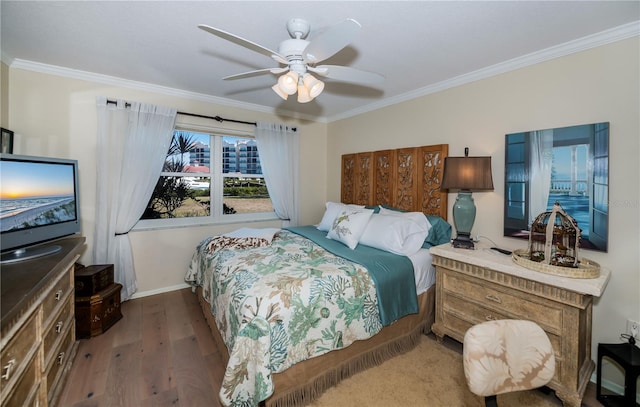 bedroom featuring ceiling fan, dark hardwood / wood-style flooring, and crown molding