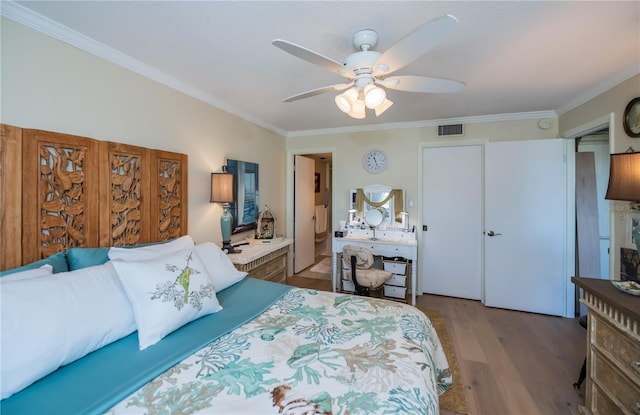 bedroom featuring ceiling fan, crown molding, and wood-type flooring