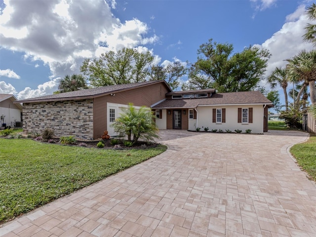 1141 Sleepy Hollow Ct, Venice, FL 34285 - view of front of property featuring decorative driveway, a front yard, stucco siding, and a shingled roof