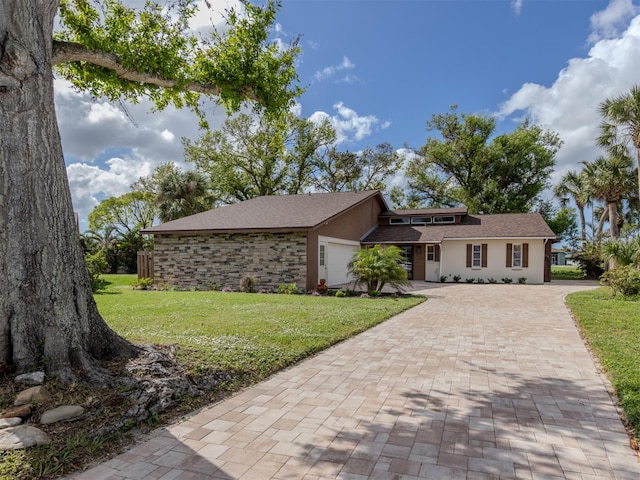 ranch-style house featuring a garage and a front lawn