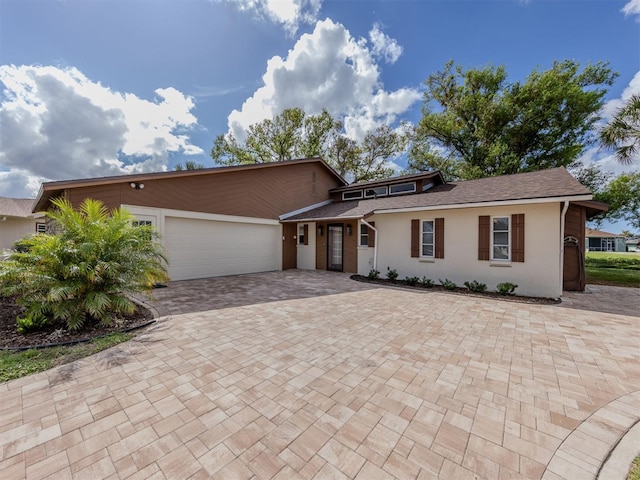 1141 Sleepy Hollow Ct, Venice, FL 34285 - view of front of house with a garage, decorative driveway, stucco siding, and a shingled roof
