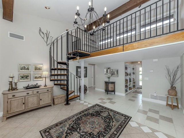 staircase with tile patterned floors, a towering ceiling, and a chandelier