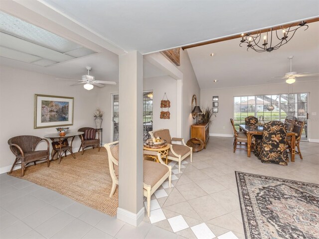 interior space featuring vaulted ceiling and ceiling fan with notable chandelier