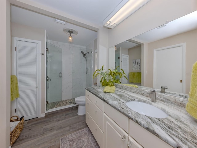 bathroom with vanity, hardwood / wood-style flooring, toilet, and an enclosed shower