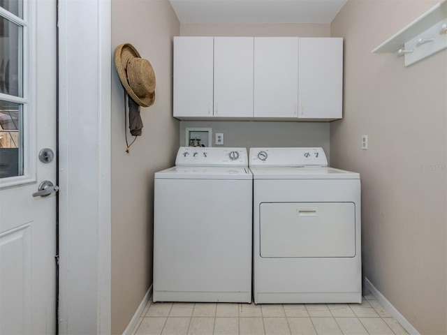 laundry area with separate washer and dryer, light tile patterned floors, and cabinets