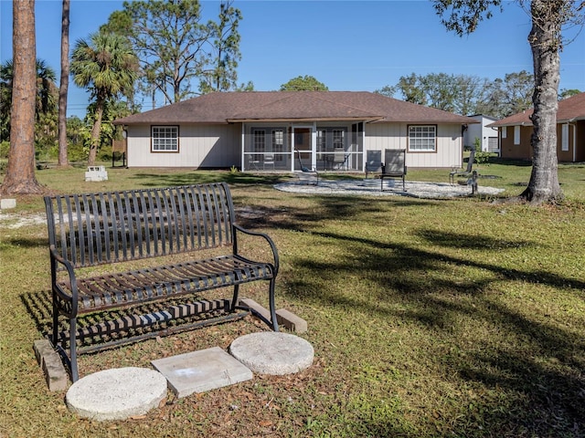 back of property with a yard and a sunroom