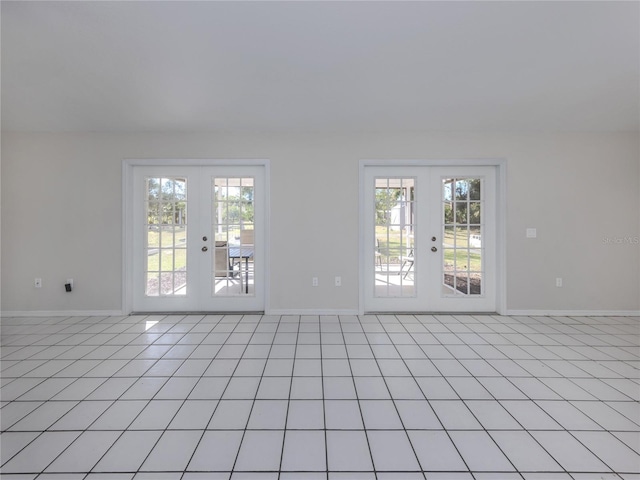 spare room with french doors, light tile patterned floors, and a wealth of natural light