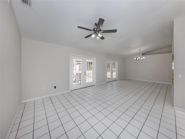 tiled empty room featuring ceiling fan with notable chandelier, lofted ceiling, and french doors