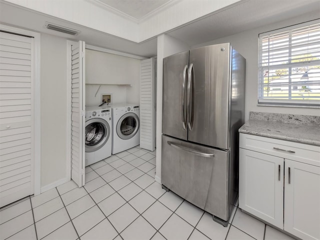 laundry room with light tile patterned floors, separate washer and dryer, and ornamental molding