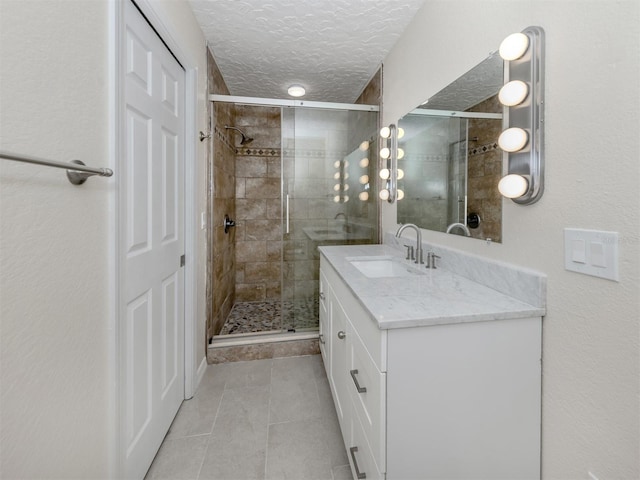 bathroom with tile patterned flooring, vanity, and a shower with door