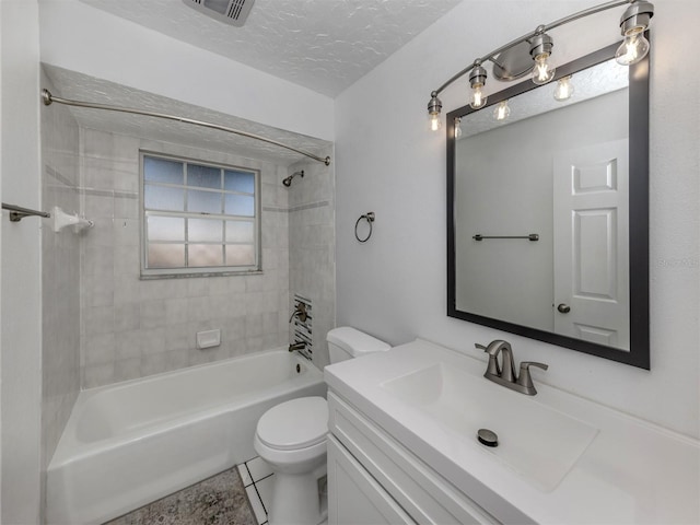 full bathroom featuring vanity, a textured ceiling, tile patterned flooring, toilet, and tiled shower / bath