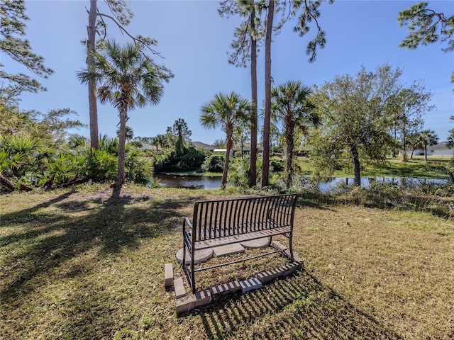 surrounding community with a lawn and a water view