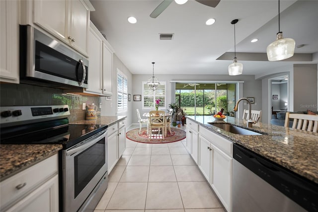 kitchen featuring white cabinets, ceiling fan with notable chandelier, sink, dark stone countertops, and stainless steel appliances