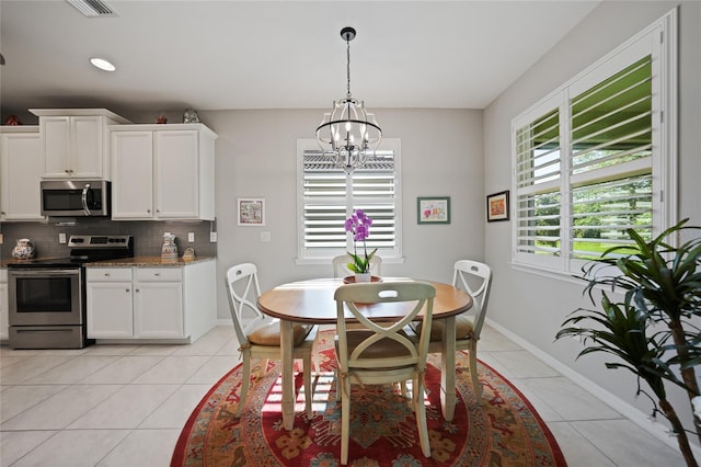 tiled dining space featuring an inviting chandelier