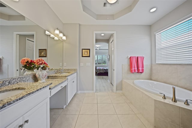 bathroom with tile patterned floors, tiled bath, and vanity