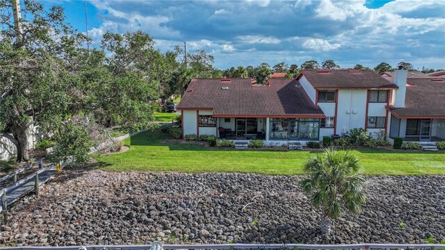 view of front of home with stucco siding, a tile roof, and a front lawn