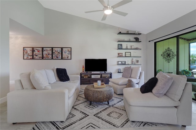 living area featuring ceiling fan, baseboards, and lofted ceiling