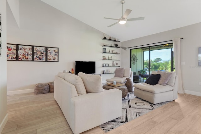 living room featuring a ceiling fan, baseboards, light wood-style floors, and high vaulted ceiling